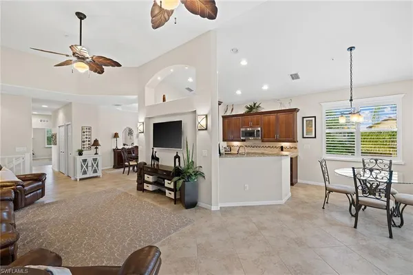a living room with furniture a flat screen tv and a large window