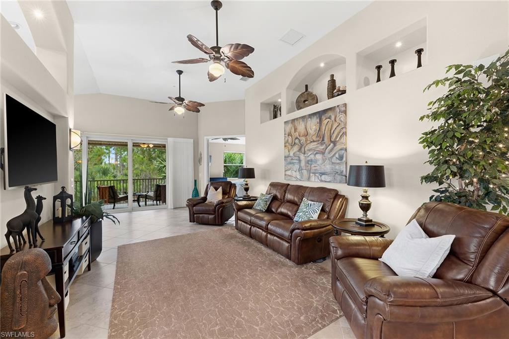 6669 Alden Woods Circle, Unit 7201 Naples, FL 34113 - Photo 8 of 28 a living room with furniture a flat screen tv and a large window