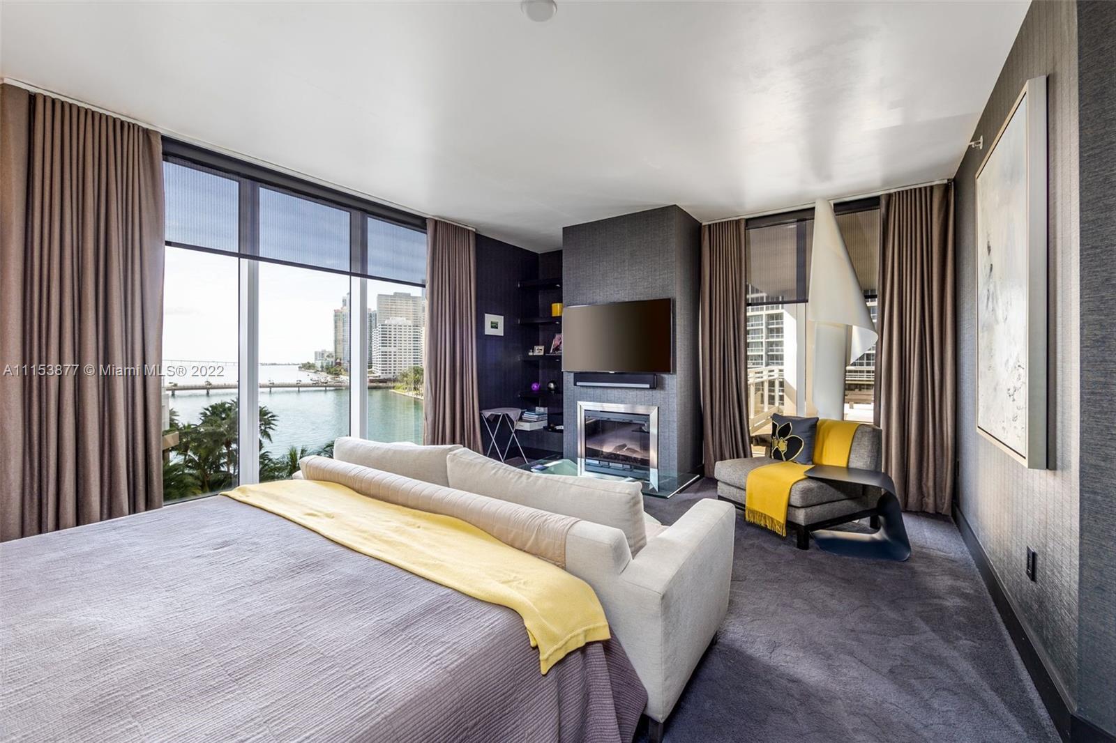 901 Brickell Key Boulevard, Unit 704 Miami, FL 33131 - Photo 11 of 39 a bedroom with a bed and a flat tv screen next to a window