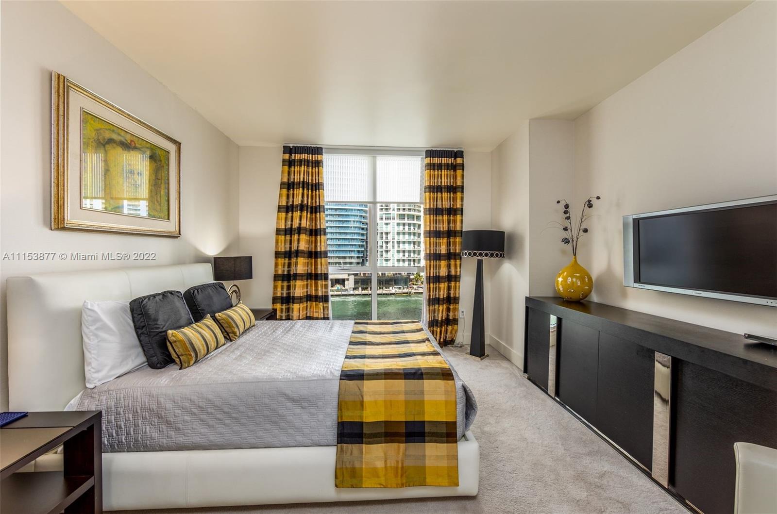 901 Brickell Key Boulevard, Unit 704 Miami, FL 33131 - Photo 13 of 39 a bedroom with a bed and flat screen tv