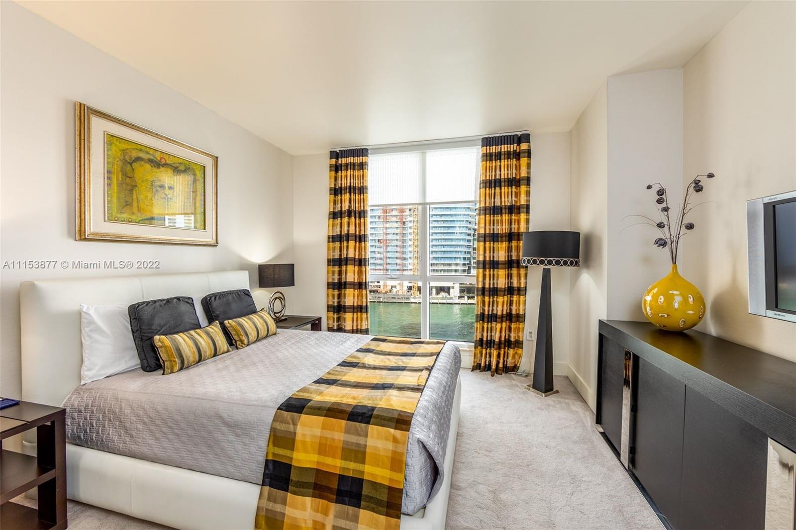 901 Brickell Key Boulevard, Unit 704 Miami, FL 33131 - Photo 15 of 39 a bedroom with a bed and wooden floor