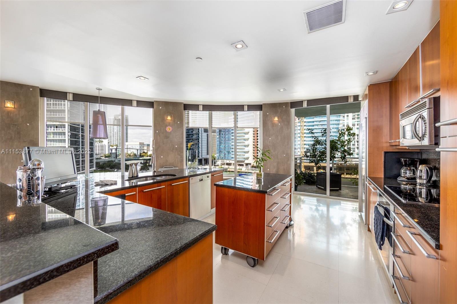901 Brickell Key Boulevard, Unit 704 Miami, FL 33131 - Photo 5 of 39 a large kitchen with stainless steel appliances granite countertop a large window and a counter space