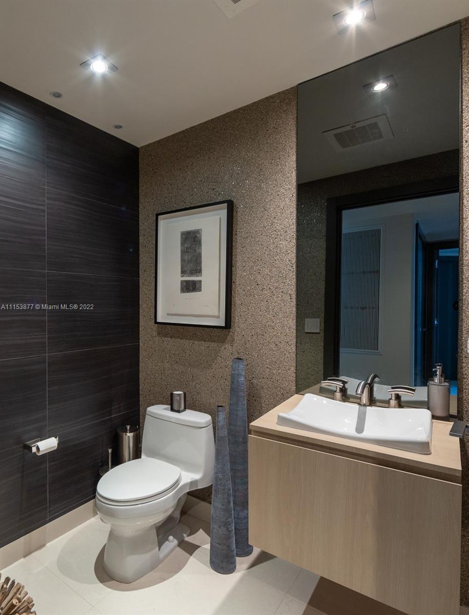 901 Brickell Key Boulevard, Unit 704 Miami, FL 33131 - Photo 8 of 39 a bathroom with a toilet a sink and mirror