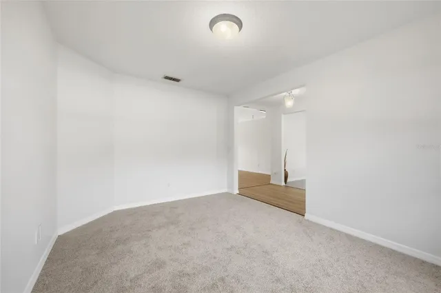 a view of empty room with wooden floor and ceiling fan