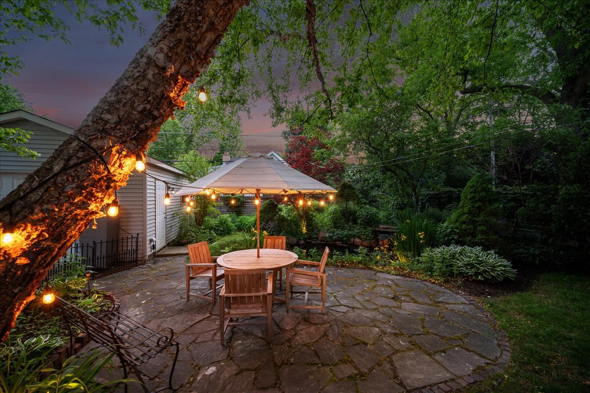 712 Juniper Road Glenview, IL 60025 - Photo 26 of 33 a view of a table and chairs under an umbrella in a backyard