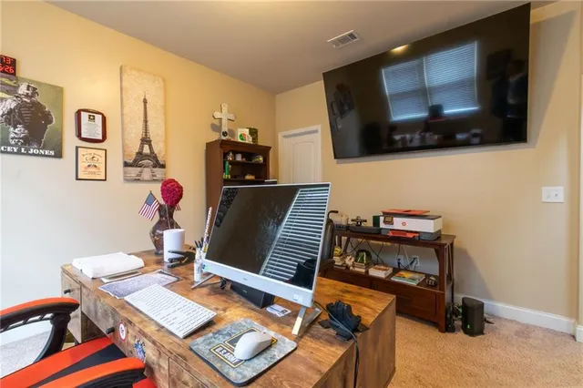 a view of a workspace with furniture and flat screen tv