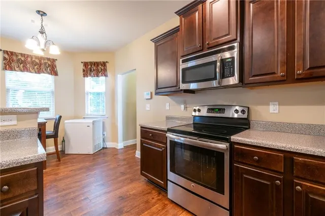 a kitchen with stainless steel appliances wooden cabinets and a stove top oven