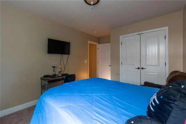 a bedroom with a bed and a flat tv screen on a dresser