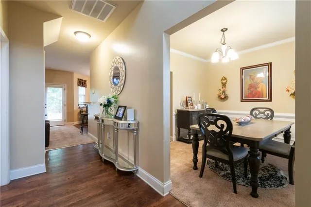 a view of a dining room and livingroom with furniture wooden floor a chandelier