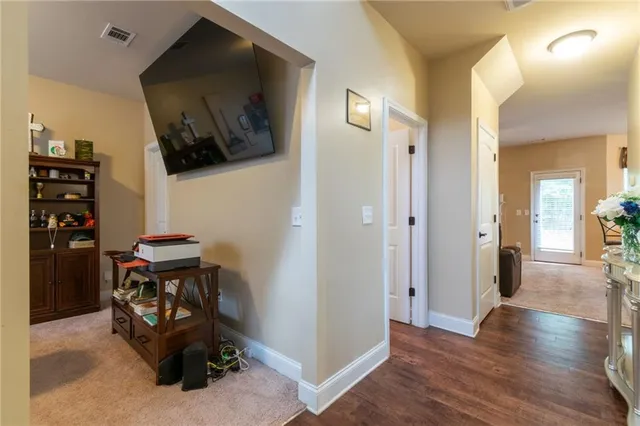 a view of a hallway with wooden floor and furniture