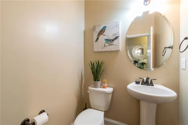 a bathroom with a toilet a sink and mirror