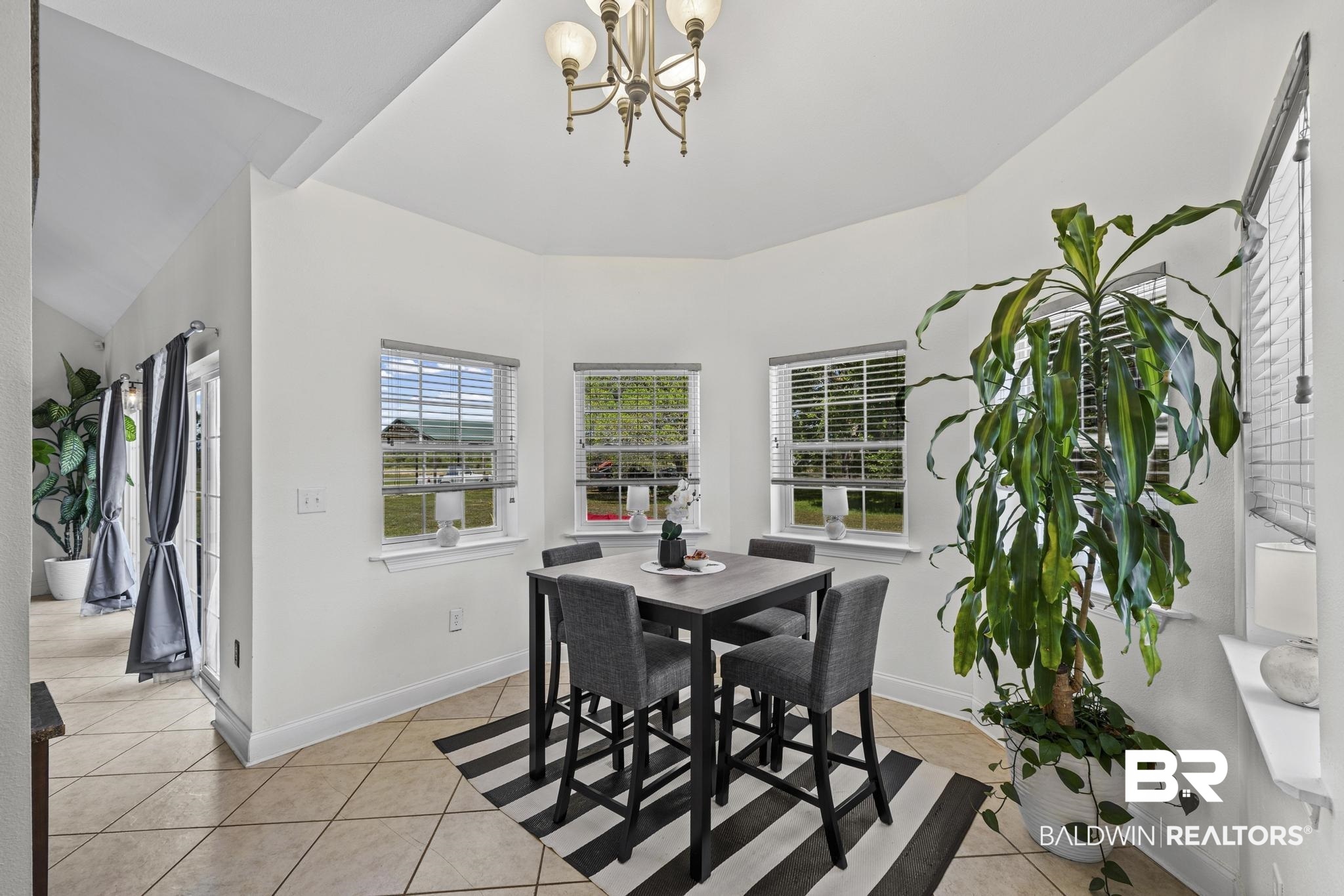 32875 Faircloth Road Lillian, AL 36549 - Photo 25 of 85 Dining room with light tile patterned floors and a chandelier