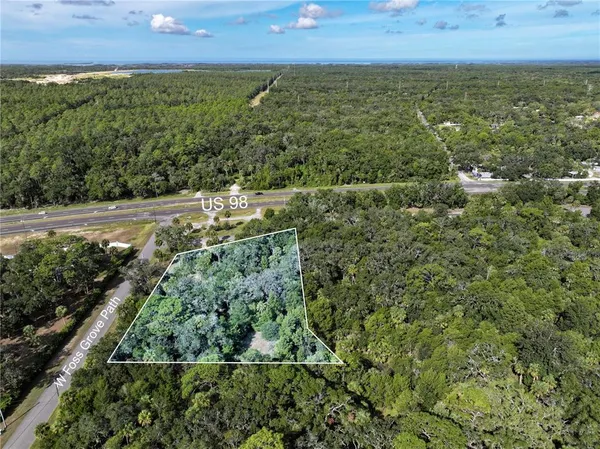 an aerial view of residential houses with outdoor space and trees