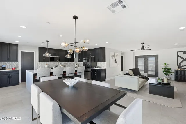 a kitchen with stainless steel appliances granite countertop a sink a oven a counter space and living room view