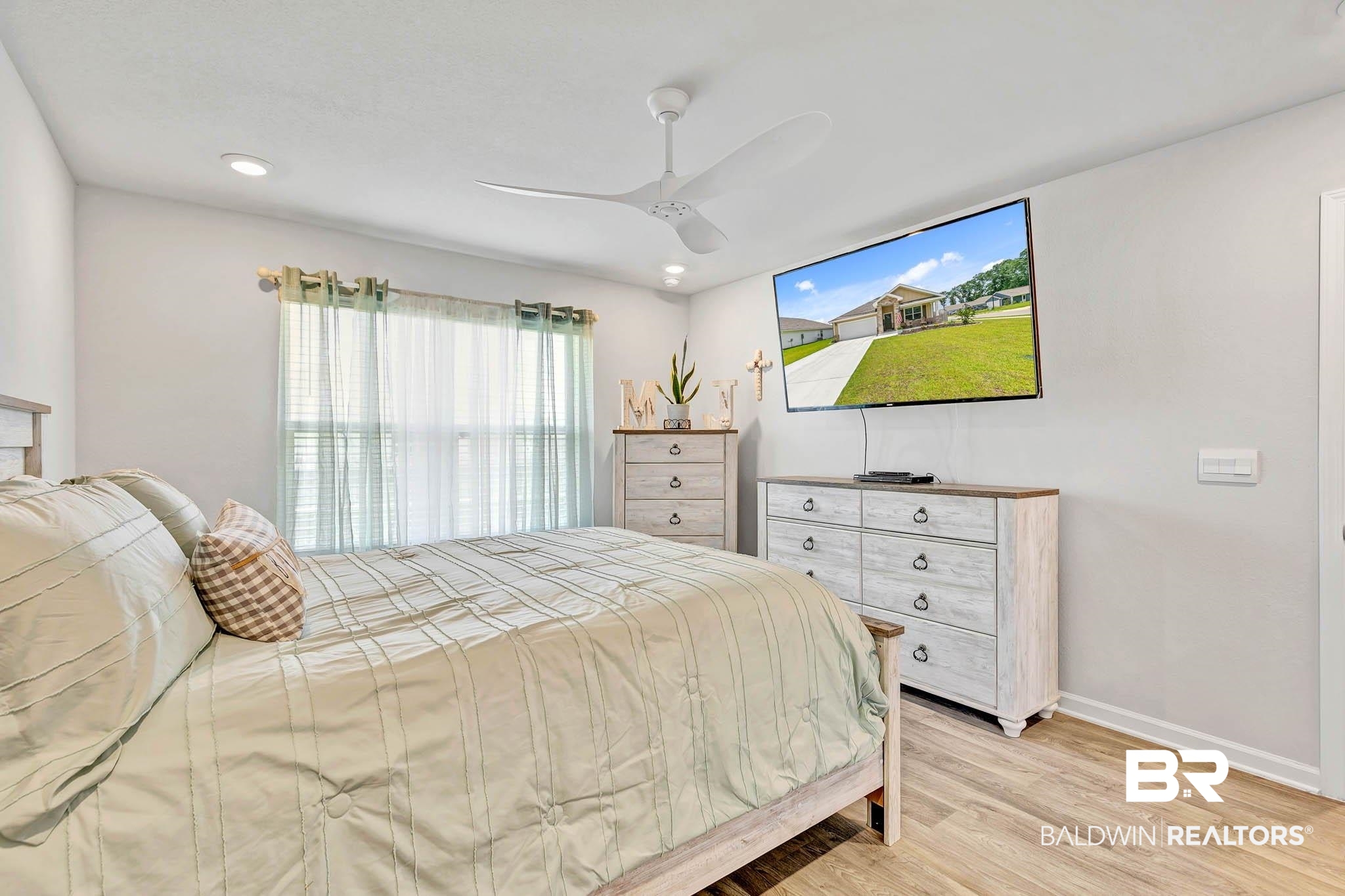 17217 REFLECTION Street Loxley, AL 36551 - Photo 22 of 83 Primary Bedroom off the great room with light wood lvp finished floors, a ceiling fan, and recessed lighting