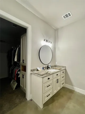 a bathroom with a granite countertop sink mirror vanity and a mirror