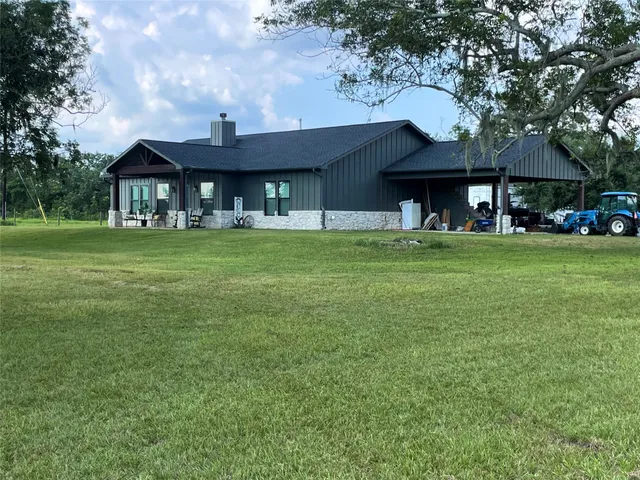 a view of a building next to a big yard with large trees
