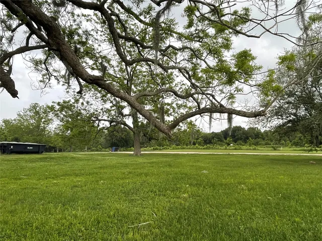 a view of a green field with wooden fence