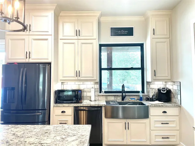 a kitchen with stainless steel appliances granite countertop a refrigerator and a sink