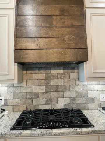 a kitchen with kitchen island granite countertop a sink and refrigerator