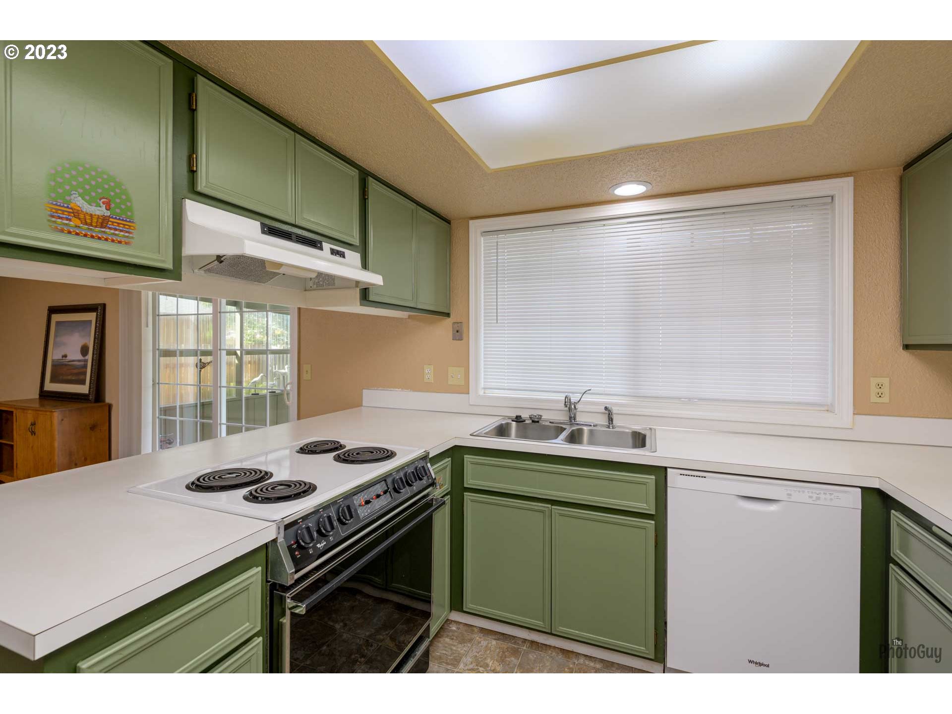 4888 B Street Springfield, OR 97478 - Photo 12 of 32 a kitchen with kitchen island a sink stove and cabinets