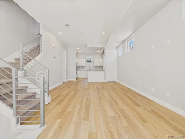 a view of empty room with wooden floor and windows