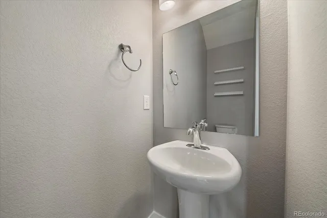 a bathroom with a sink a light fixture and a mirror