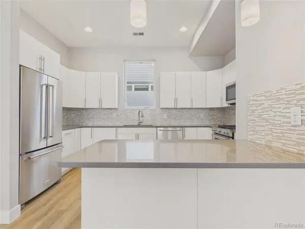 a kitchen with stainless steel appliances granite countertop a refrigerator a sink and a stove