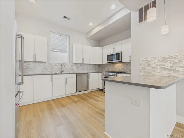 a kitchen with stainless steel appliances granite countertop a stove a sink and a microwave