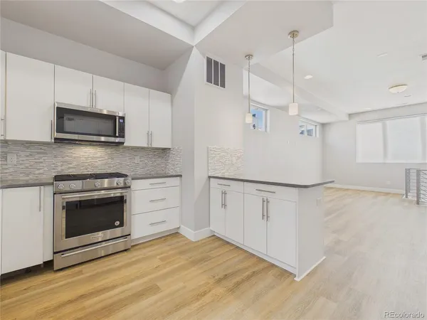 a kitchen with granite countertop white cabinets and stainless steel appliances