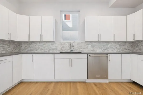 a kitchen with granite countertop white cabinets and sink