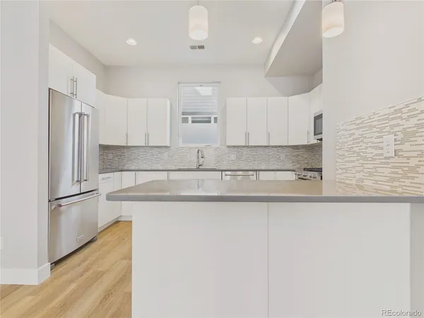 a kitchen with stainless steel appliances granite countertop a sink and a refrigerator