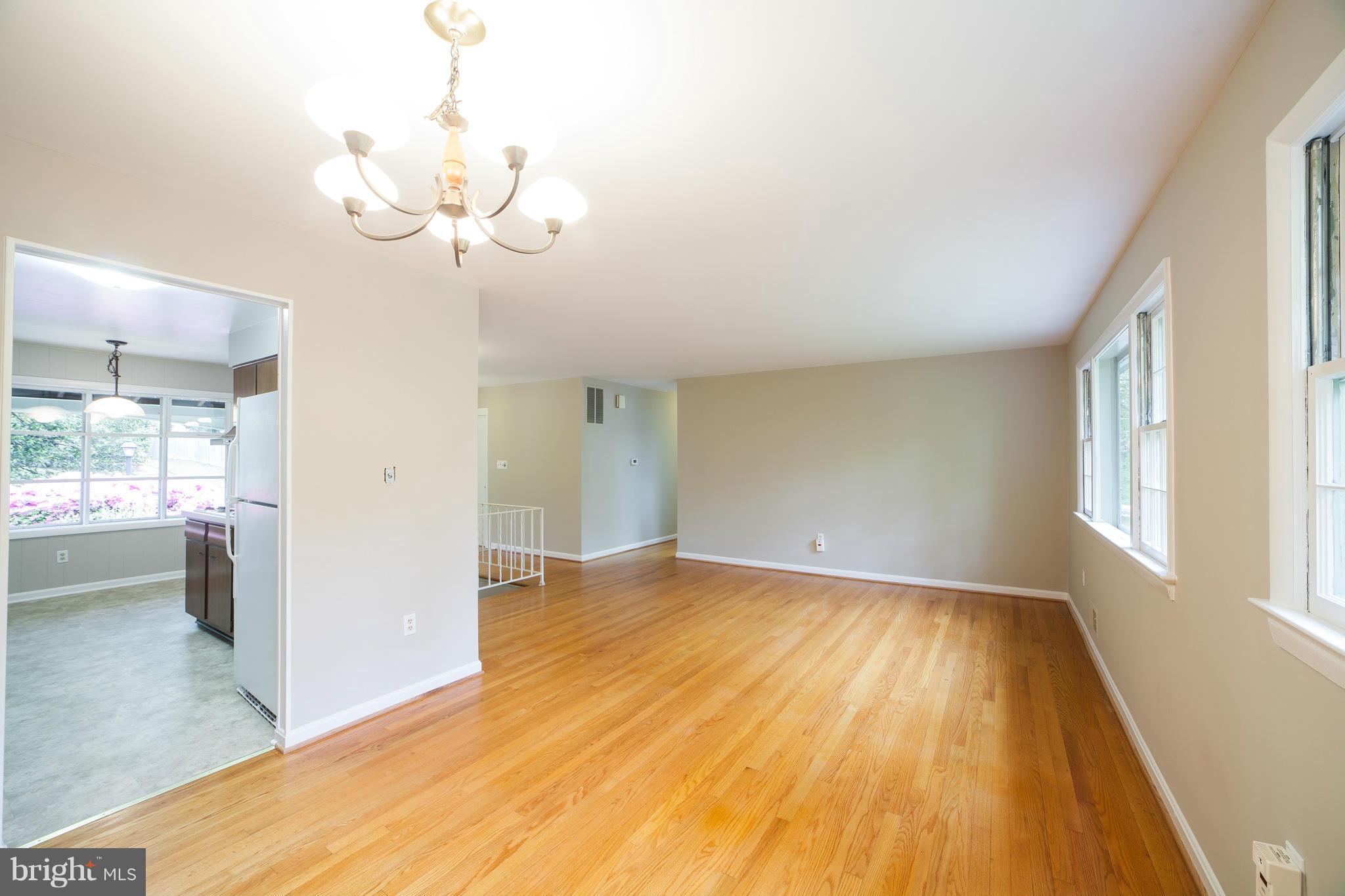 13133 Clifton Road Silver Spring, MD 20904 - Photo 5 of 29 a view of an empty room with wooden floor and a window