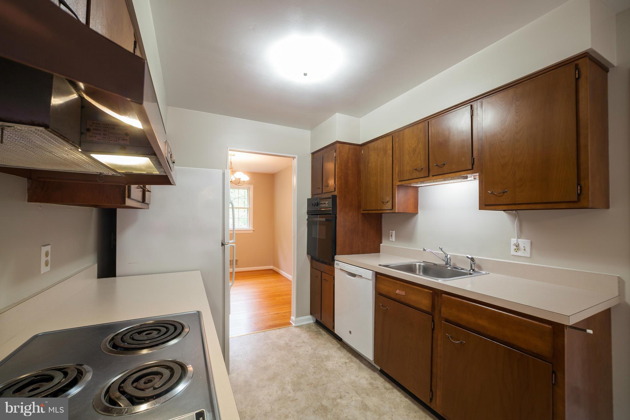 13133 Clifton Road Silver Spring, MD 20904 - Photo 8 of 29 a kitchen with stainless steel appliances a sink a stove a refrigerator and cabinets