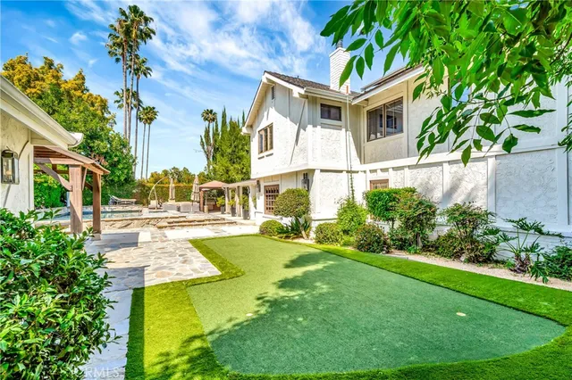 a patio with a table and chairs and potted plants
