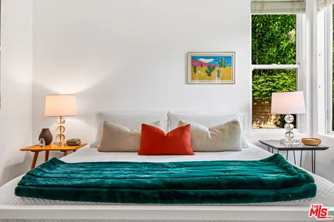 a bed room with a bed and a large window