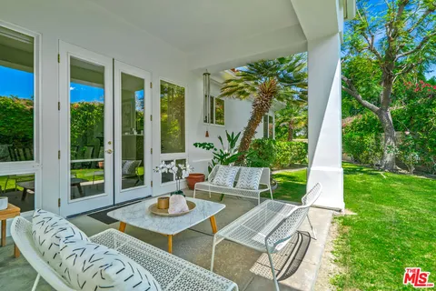 a front view of a house with a yard and potted plants