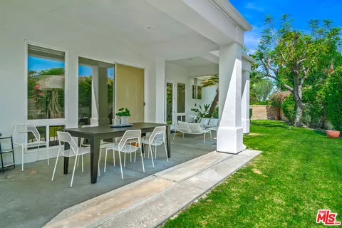 a view of a swimming pool with a patio and a yard