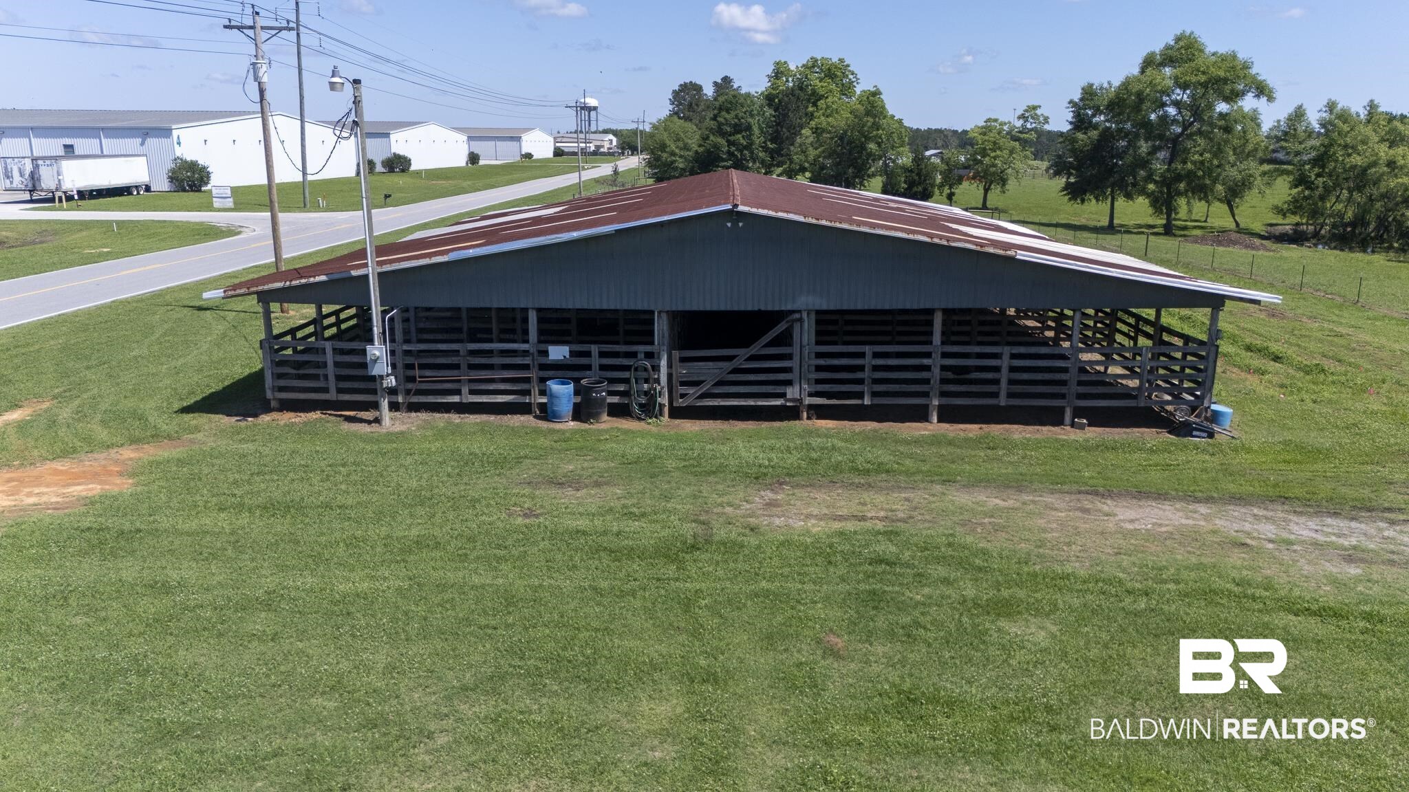 30580 County Road 49 Loxley, AL 36551 - Photo 31 of 32 Open-sided barn structure featuring a corrugated metal roof and horizontal wood fencing
