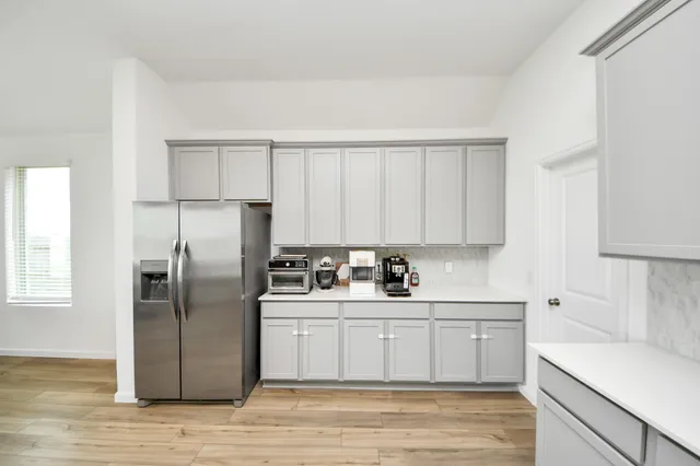 a kitchen with a sink a refrigerator and cabinets