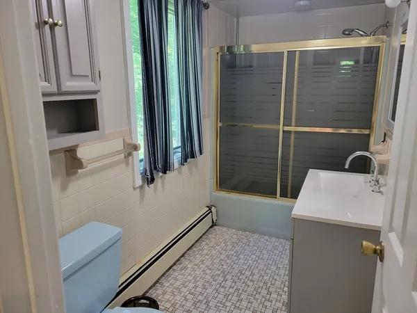 a bathroom with a tub a sink and a large mirror