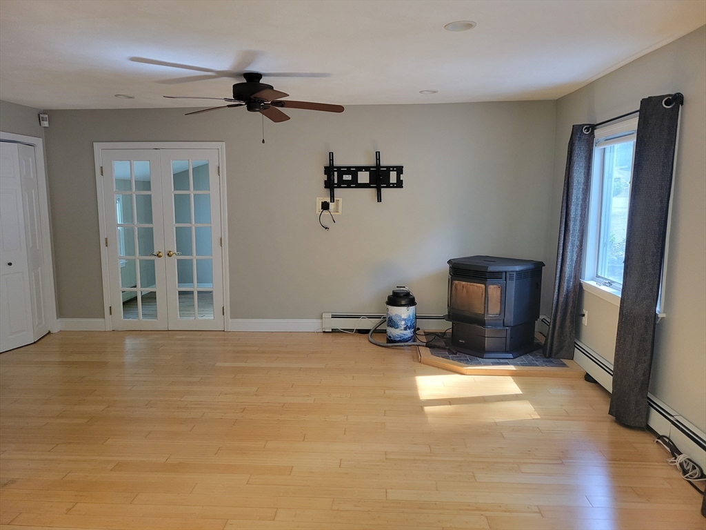 37 Golden Hills Road, Unit 37 Saugus, MA 01906 - Photo 9 of 22 a view of a livingroom with a fireplace a ceiling fan and windows