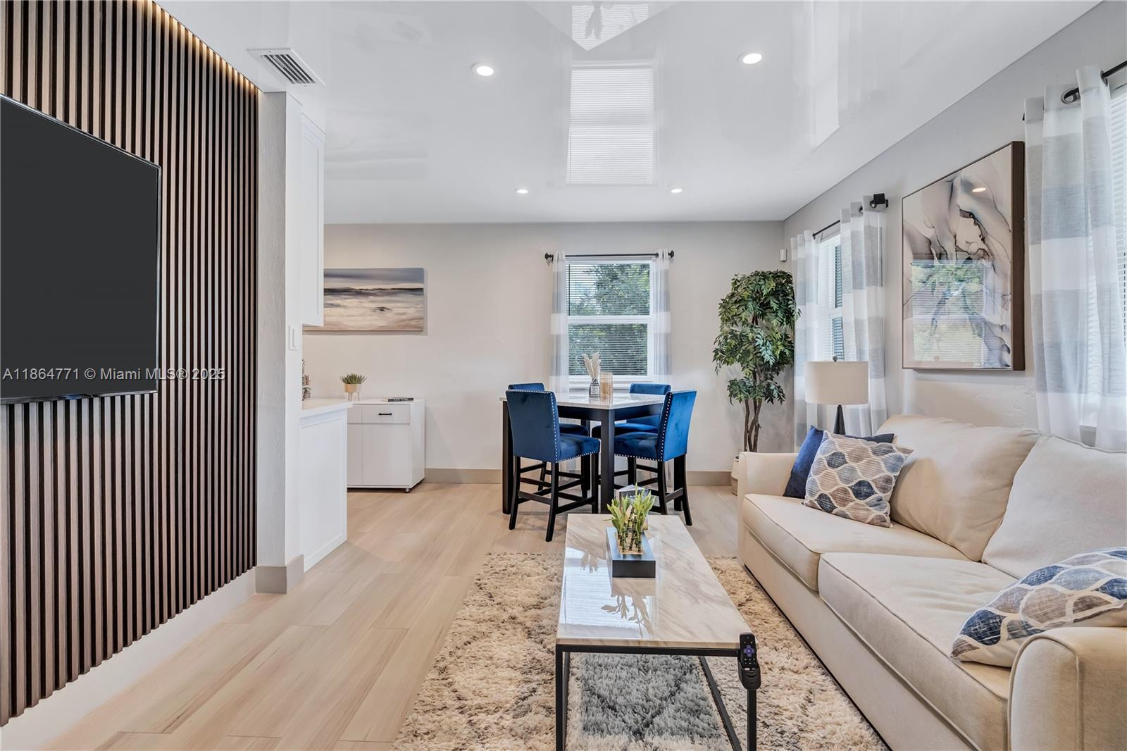 a living room with furniture a large window and a flat screen tv