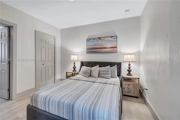 a bedroom with a bed and a painting on the wall