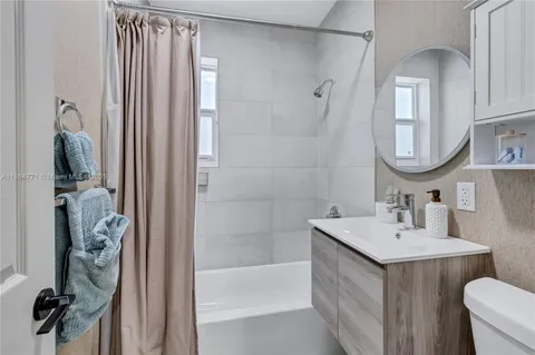 a bathroom with a sink vanity toilet and shower