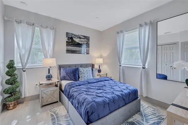 a bedroom with a large bed and a potted plant