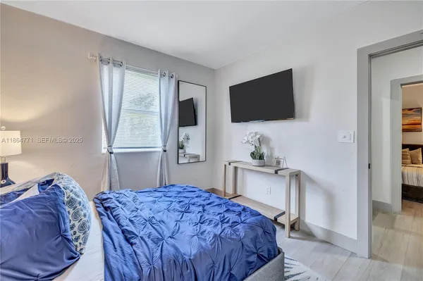 a bedroom with a bed and a flat screen tv