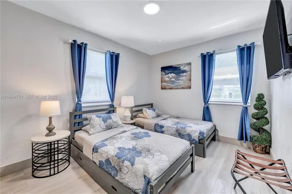 a bedroom with two beds and a flat screen tv