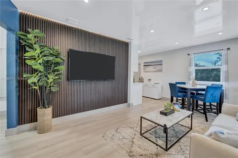 a living room with furniture a flat screen tv and a potted plant