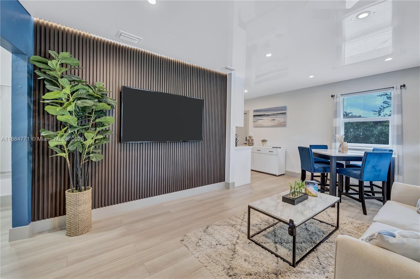 1390 Northeast 150th Street Miami, FL 33161 - Photo 2 of 31 a living room with furniture a flat screen tv and a potted plant
